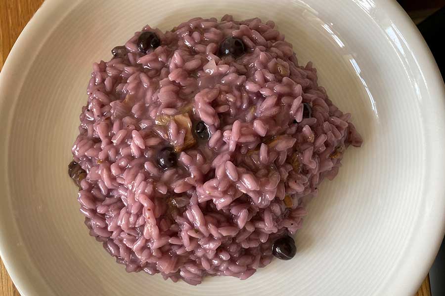 Ein Teller mit Blaubeerrisotto/Risotto ai Mirtilli